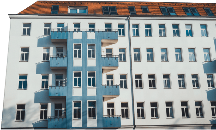 Mehrfamilienhaus mit weißen Wänden und blauen Balkonen, mehrere Fenster in gleichmäßiger Anordnung.